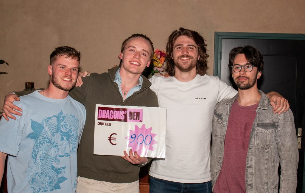 Four of the UNAMIQ founders holding a Dragons’ Den prize cheque